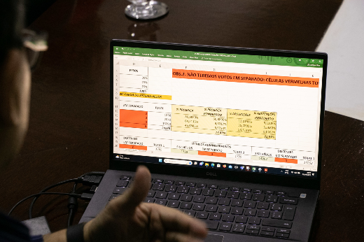 Imagem: Homem visualizando tela de notebook do sistema Helios, utilizado na consulta (Foto: Viktor Braga/UFC)