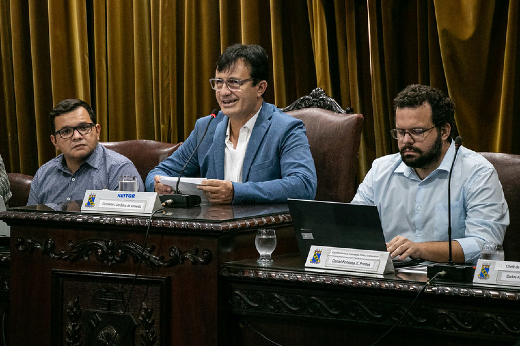 Imagem: Foto posada do reitor Custódio Almeida discursando na tribuna da sala do Conselho Universitário