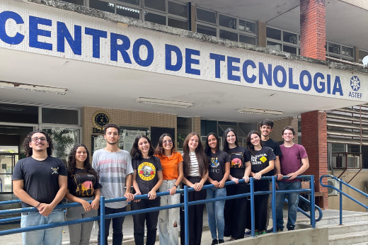 Imagem: foto de 11 jovens em pé embaixo de uma laje onde está escrito Centro de Tecnologia