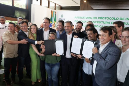 Imagem: Foto do reitor Custódio Almeida, do ministro Camilo Santana, do governador Elmano e de outras pessoas segurando os termos de cooperação assinados para a doação do terreno do Acquario Ceará