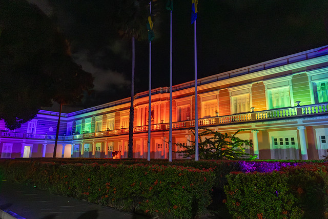 O GT é responsável por formular propostas de políticas institucionais voltadas à garantia de direitos, acolhimento, permanência e valorização das pessoas trans na UFC (Foto: Ribamar Neto/UFC) Fachada do prédio da Reitoria da UFC iluminado com luzes coloridas imitando um arco-íris