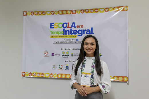 Imagem: foto de Edinalva Campos, mulher de cabelos lisos longos e na cor castanha, veste blusa branca