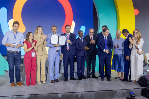 Imagem: Foto do governador Elmano de Freitas segurando a lei sobre alimentação escolar sancionada por ele