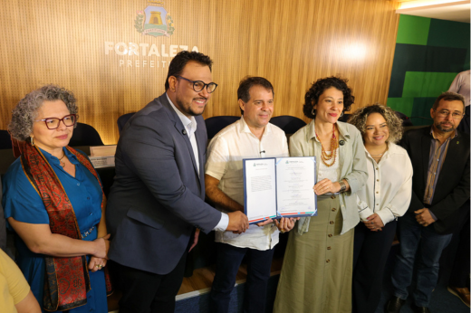 Imagem: Foto do prefeito Evandro Leitão erguendo um documento oficial assinado