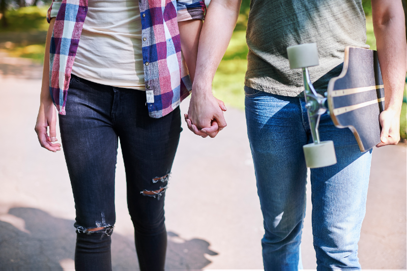 Imagem: jovens caminham de mãos dadas