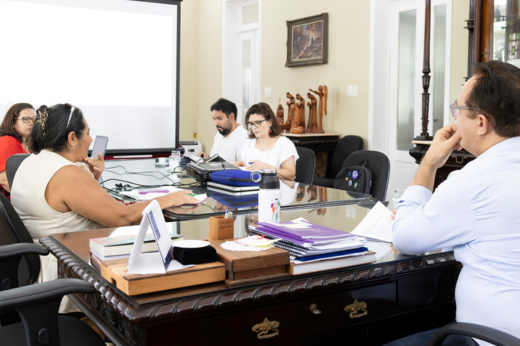 Pessoas reunidas na mesa do Gabinete da Reitoria, durante reunião