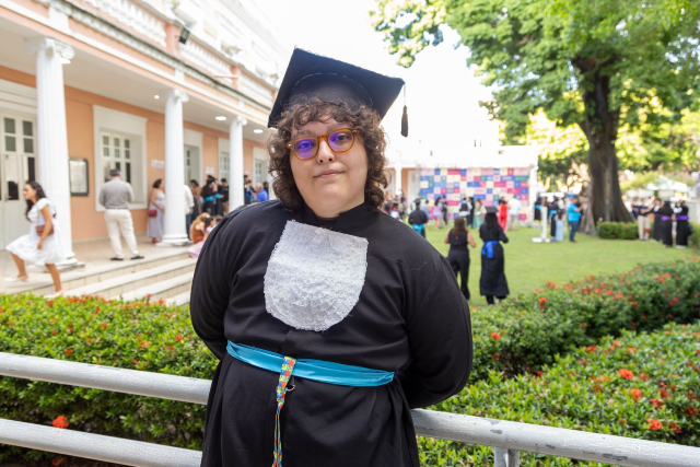 Imagem: formanda posa no jardim da Reitoria