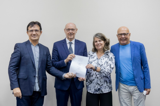 Imagem: O reitor Custódio Almeida e os convidados do evento seguram a carta-acordo assinada pelos representantes das instituições parceiras do projeto
