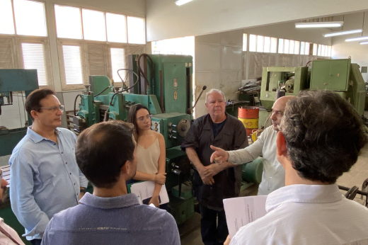 Pessoas no laboratório de máquinas operatrizes, vendo os equipamentos e ouvindo a explicação sobre o espaço