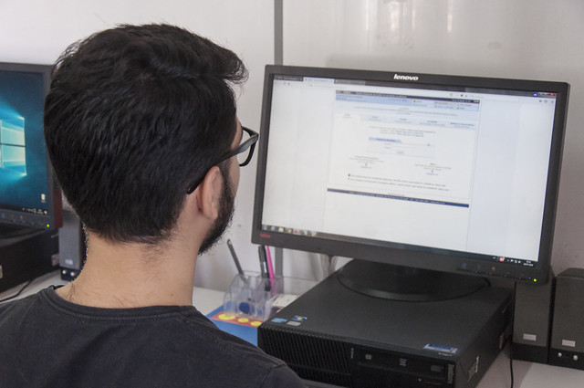 Fotografia de uma pessoa de costas utilizando um computador e acessando o SI3 (Foto: Viktor Braga/UFC)