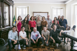 Imagem: um grupo de pessoas posam para foto no gabinete do reitor