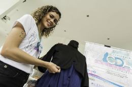 Imagem: Estudante de Design-Moda mostrando uma peça de roupa feita especialmente para um evento de moda inclusiva (Foto: Jr Panela/UFC)