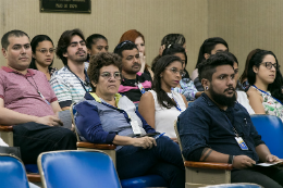 Imagem: foto de terceirizados sentados no auditório olhando para o palco