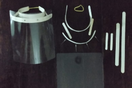 Foto da viseira de acetato, dos elásticos e dos suportes de PVC que compõem o protetor facial