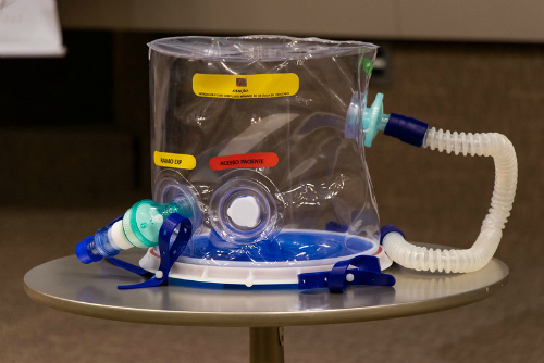 Imagem: Capacete de respiração assistida Elmo repousa sobre mesa na coletiva de lançamento. (Foto: Viktor Braga/ UFC Informa)