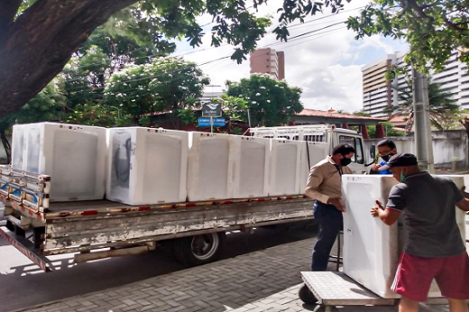 Imagem: Equipe descarrega novas lavadoras entregues nas residências universitárias do Benfica e Pici.