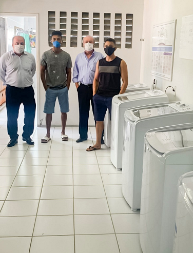 Imagem: Reitor Cândido Albuquerque (à direita) entrega a estudantes novos equipamentos, parte deles já em uso na residência universitária do Pici.