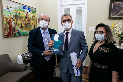 Imagem: Reitor Cândido Albuquerque (à esquerda) entrega materiais institucionais ao cônsul-geral da França Hugues Fantou; à direita, a consulesa honorária da França em Fortaleza, Fernanda Jansen. (Foto: Viktor Braga/ UFC Informa)