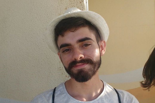 Imagem: Foto de Adriano da Costa, um jovem estudante, de pele clara, com cabelo e barba escura, usando um chapeu tipo panamá. (Foto: Acervo pessoal)