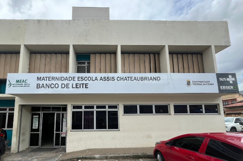 Imagem: Fachada do Banco de Leite da Maternidade-Escola Assis Chateaubriand (MEAC-UFC), com identificação da unidade, logomarcas institucionais, portas de acesso e janelas do prédio.