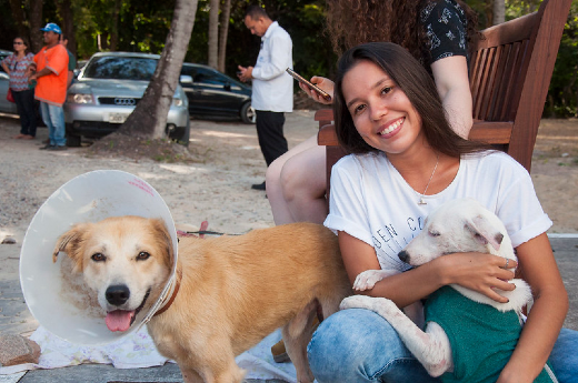 Aluna da UFC no Campus ao lado de dois cães 