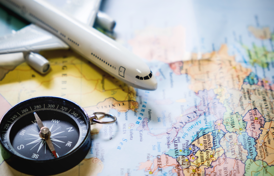 mapa mundi, bússola e miniatura de avião