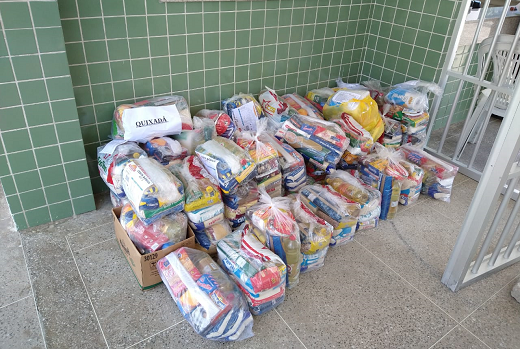 Imagem: foto de cestas básicas empilhadas em um canto no chão
