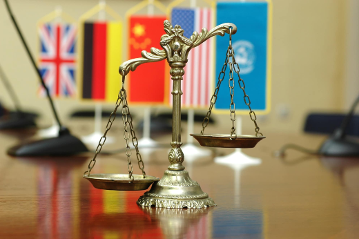 Imagem: balanço símbolo do Direito com bandeiras da ONU e de países diversos ao fundo