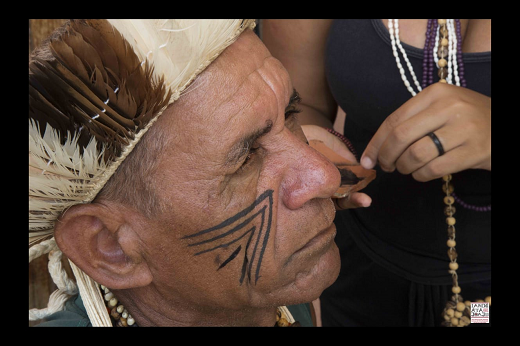 Imagem: foto de um homem negro tendo o rosto pintado com traços indígenas na cor preta