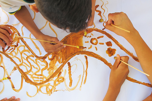 Imagem: foto de mãos de crianças desenhando em um papel em branco