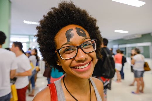 Imagem: estudante sorri para foto