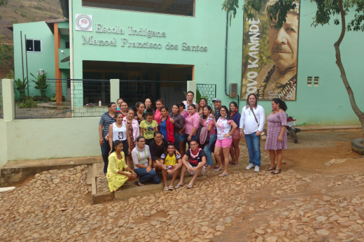 Imagem: alunos e professor em frente a escola indígena