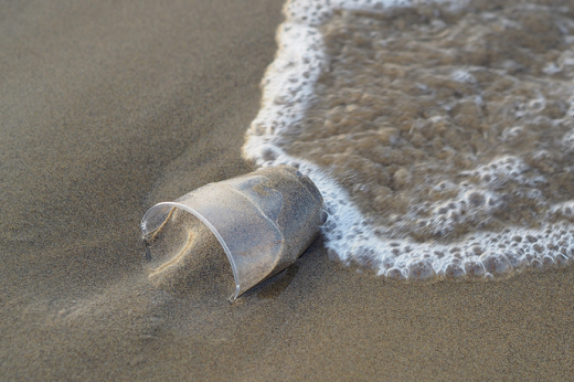 Imagem: copo plástico na areia da praia