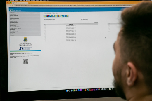 Imagem: tela de computador com uma pessoa de perfil olhando para tela