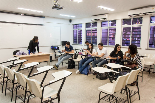 Imagem: Sala de aula com alunos sentados e professora na frente