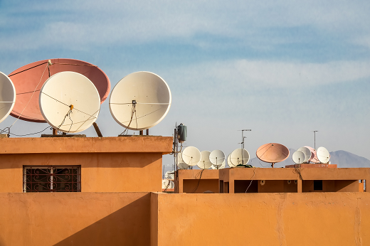 Imagem: Conjunto de antenas sobre prédio de coloração laranja