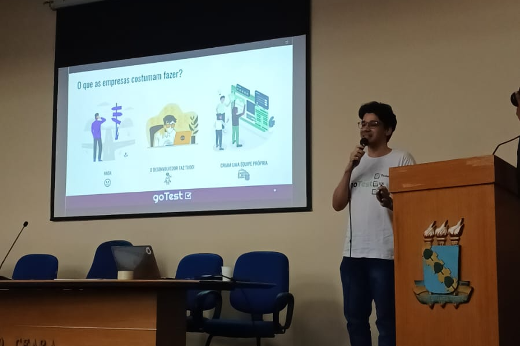 Imagem: homem apresenta slide no auditório da Reitoria