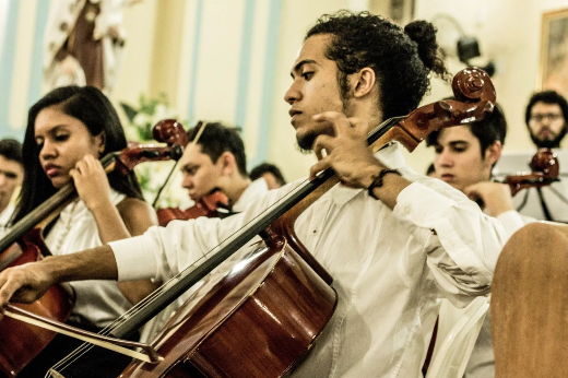 Imagem: jovens músicos se apresentam no interior de uma igreja