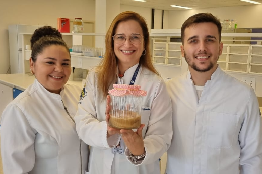 Imagem: Da direita para a esquerda: Mayara Beserra, Delane Gondim e Everton Cavalcante e ; eles estão em um laboratório, trajando uniformes brancos, posando sorridentes para a foto (Foto: Divulgação/PPGO)