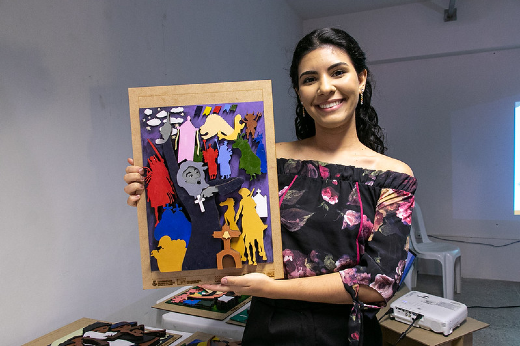 Imagem: estudante Mainara Lima segura obra de arte que apresentou nos Encontros Universitários 