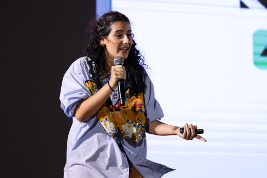 Imagem: Foto de Luana Stopa, mulher, vestindo uma blusa branca com estampa colorida ao centro (Foto: Divulgação)