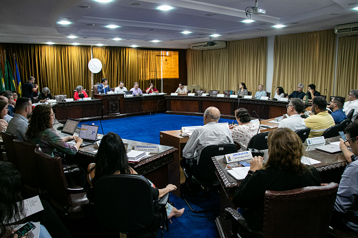 Imagem: Sala de reunião do CEPE, com vários conselheiros dispostos em cadeiras por trás de uma grande mesa em formato circular (Foto: Ribamar Neto/UFC)