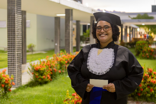 Imagem: estudante de beca posa para foto no Campus de Quixadá