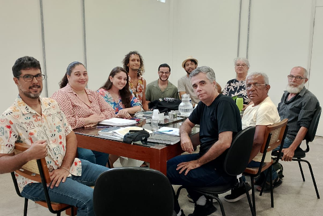 Imagem: pessoas em torno de uma mesa posam para foto