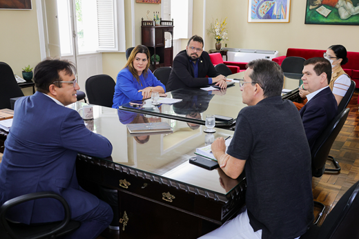 Participantes da reunião sentados à mesa no Gabinete da Reitoria
