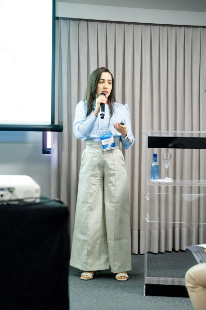 Janine Brandão de Farias é a representante do Campus da UFC em Crateús a ter um projeto aprovado no edital (Foto: arquivo pessoal) Uma mulher jovem está em pé falando ao microfone