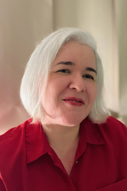 Luciana de Lima coordena o projeto “Avaliação de sequência didática tecnodocente interdisciplinar: influência do desenvolvimento autoral de jogo digital na aprendizagem de ciências da natureza no Ensino Médio” (Foto: arquivo pessoal) Uma mulher de cabelos lisos e grisalhos posa para foto. Ela usa uma blusa na cor vermelha