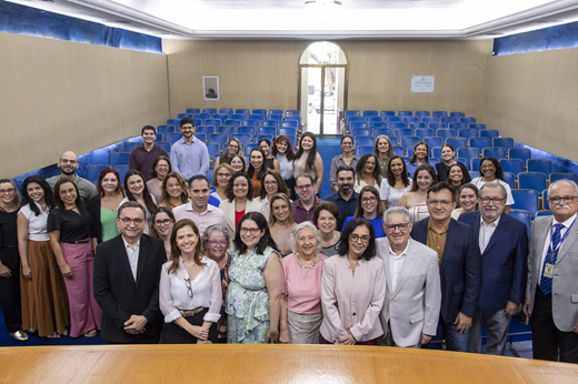 Imagem: Ao lado do reitor Custódio Almeida, da superintendete do Complexo Hospitalar, do diretor da Famed João Macedo e do coordenador do Serviço de Transplante de Medula do HUWC Fernando Bezerra, servidores do Complexo Hospitalar e público presente à solenidade posam de pé no auditório da Reitoria