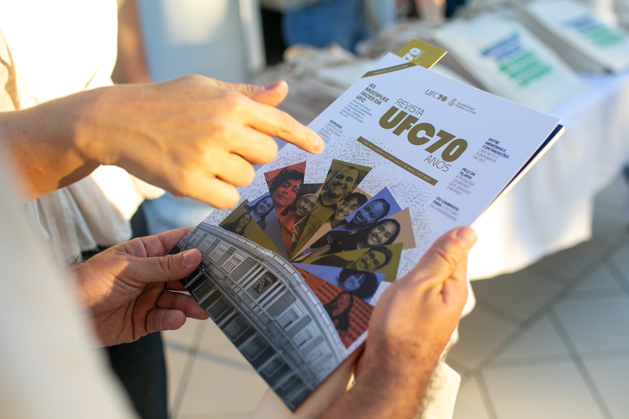 Mão segura a edição da Revista UFC 70 Anos